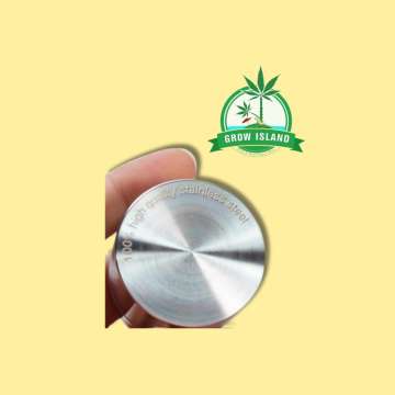 Black Leaf Steely Dan Edelstahl-Grinder with yellow background and green grow island logog in the right upper corner